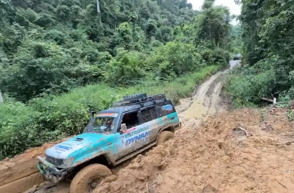 Kenderaan pasukan menuruni denai hutan yang curam