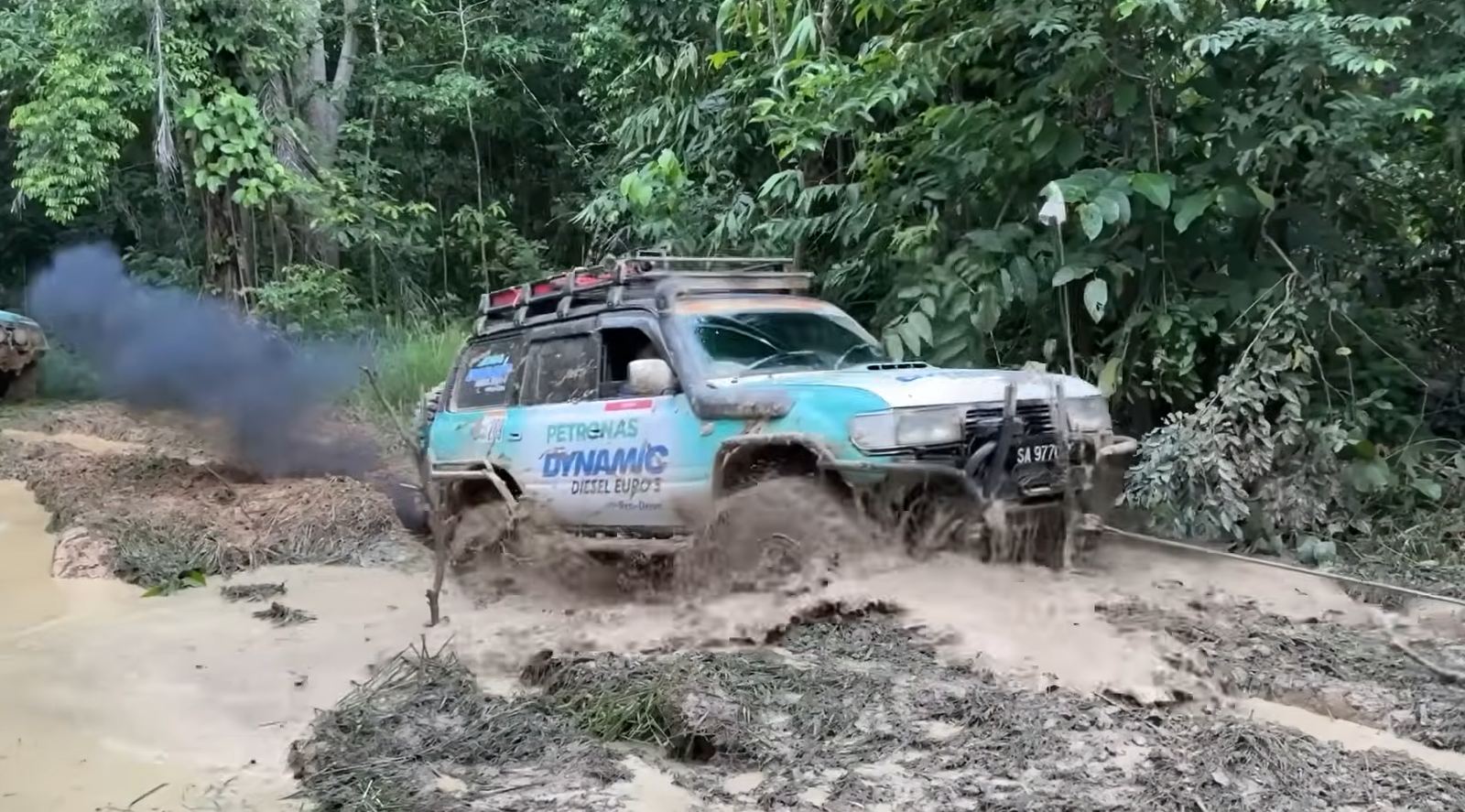 Kenderaan pasukan memercikkan lumpur ketika meredah laluan beralur