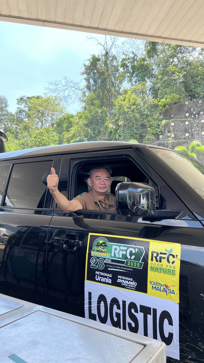 Anggota kru logistik Rainforest Challenge menunjukkan isyarat ibu jari