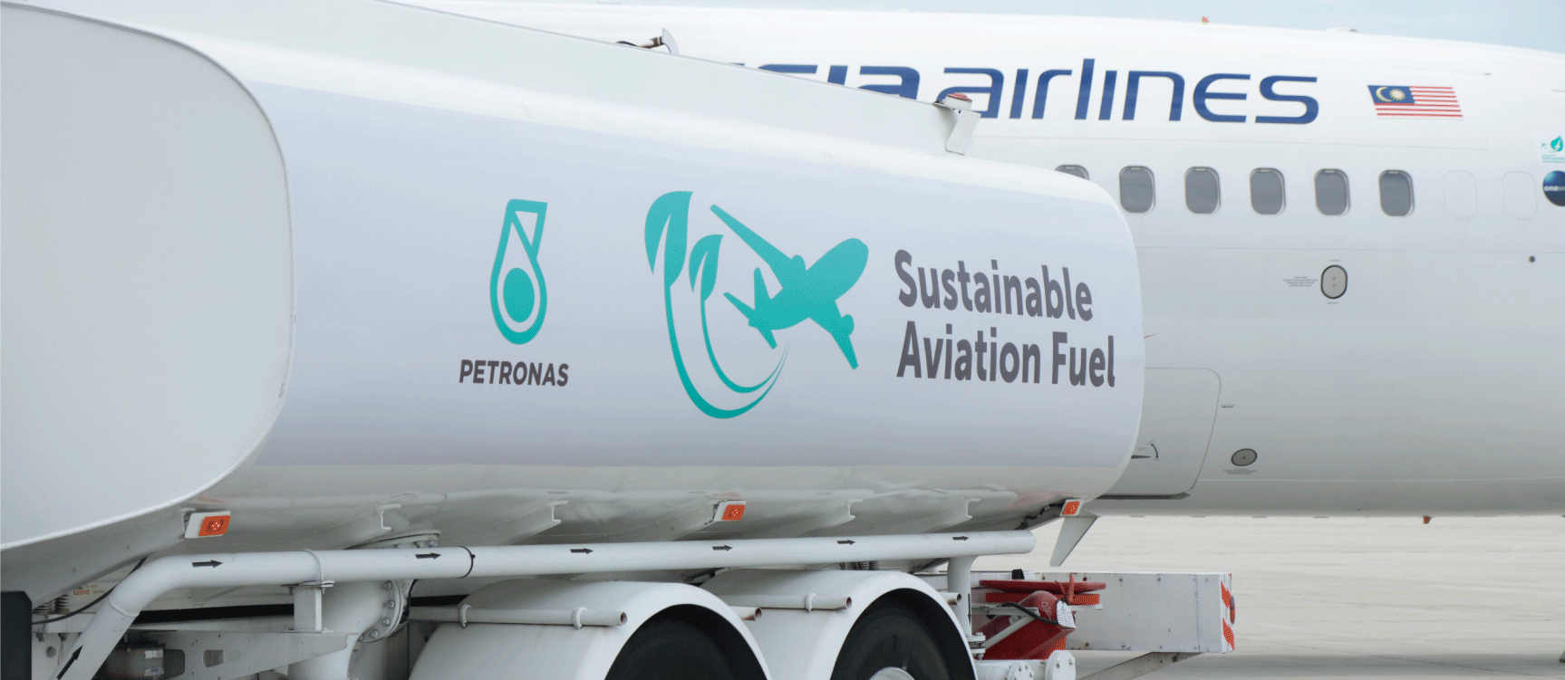 A PETRONAS Sustainable Aviation Fuel tanker beside a Malaysia Airlines aircraft
